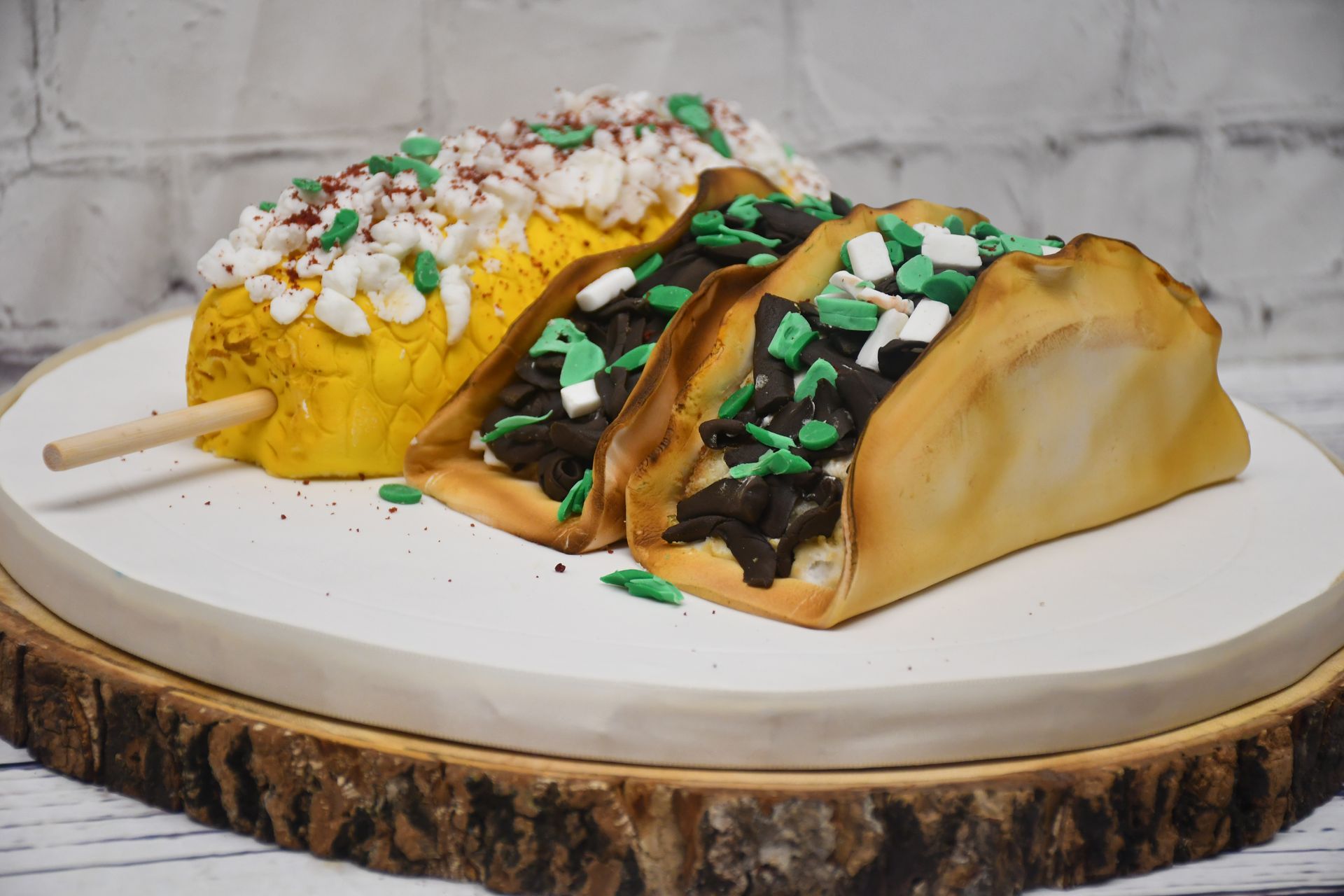 Two tacos on a stick are sitting on a wooden cutting board.