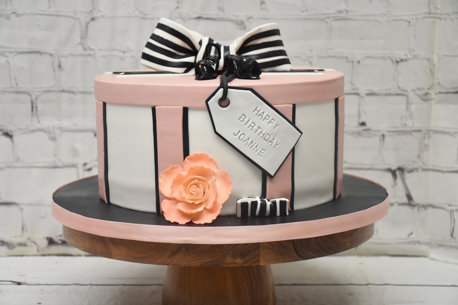 A birthday cake in the shape of a gift box with a bow.