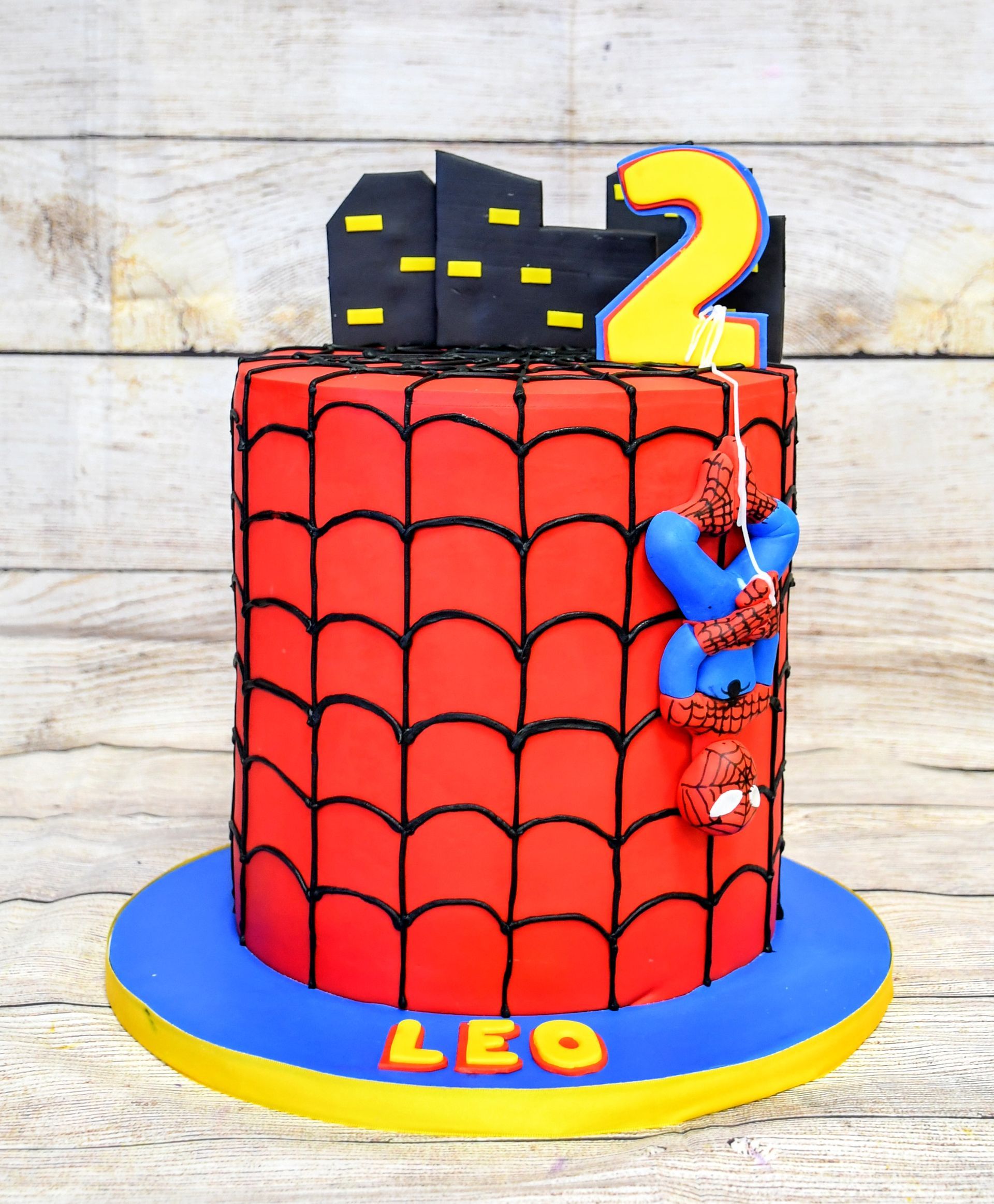 A spiderman cake with the name leo on it