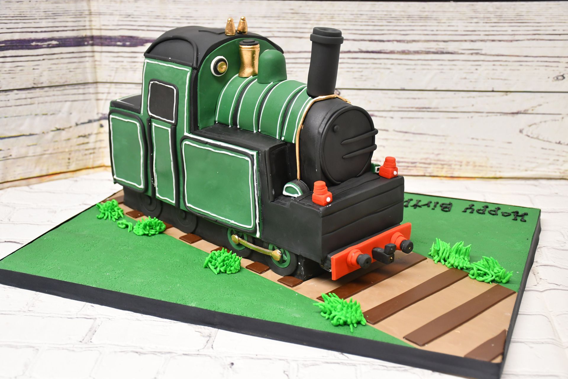 A cake in the shape of a train is sitting on a table.