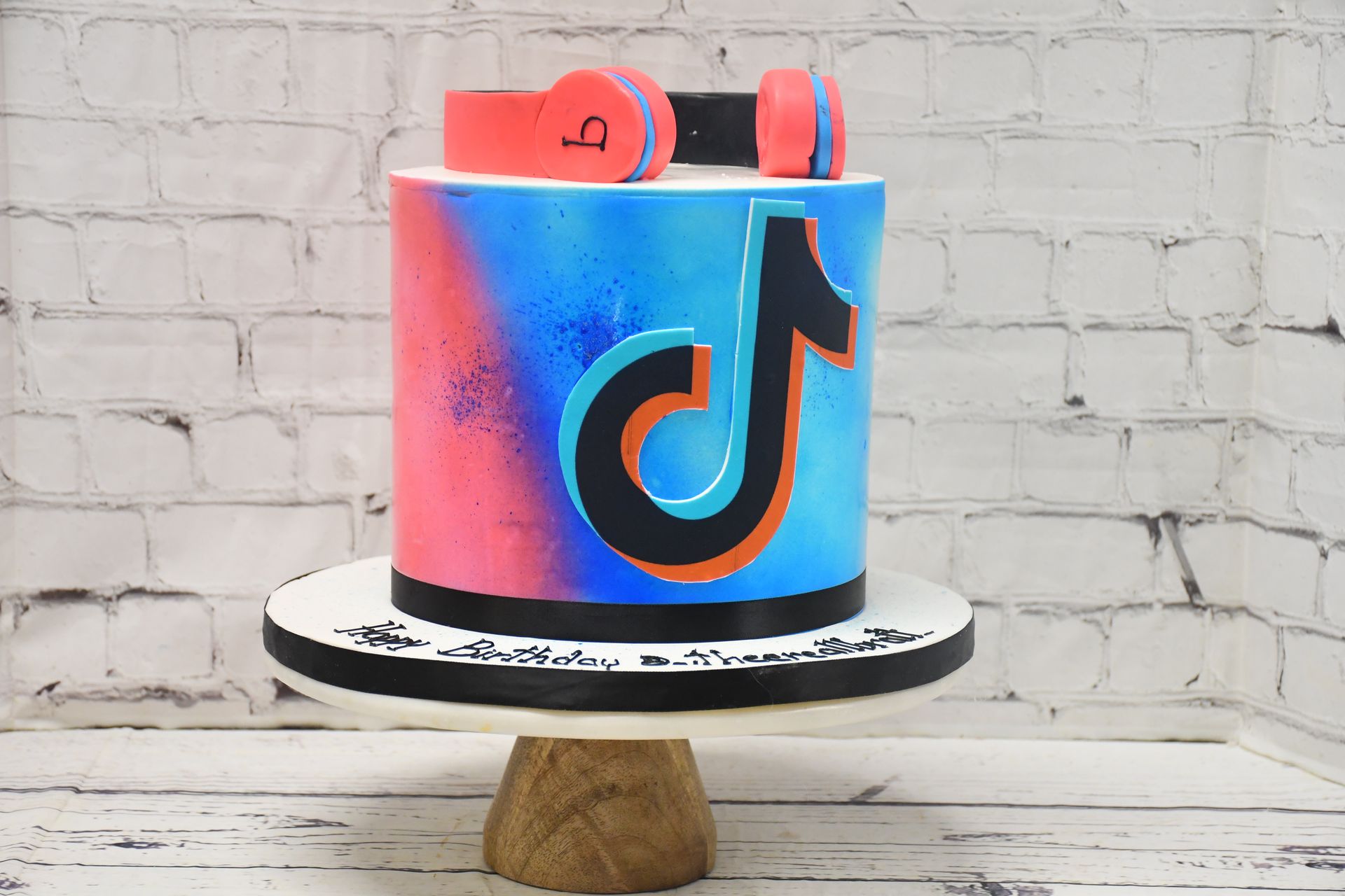 A tik tok cake with headphones on top of it.