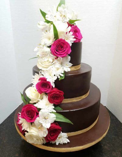 A chocolate cake with pink and white flowers on it