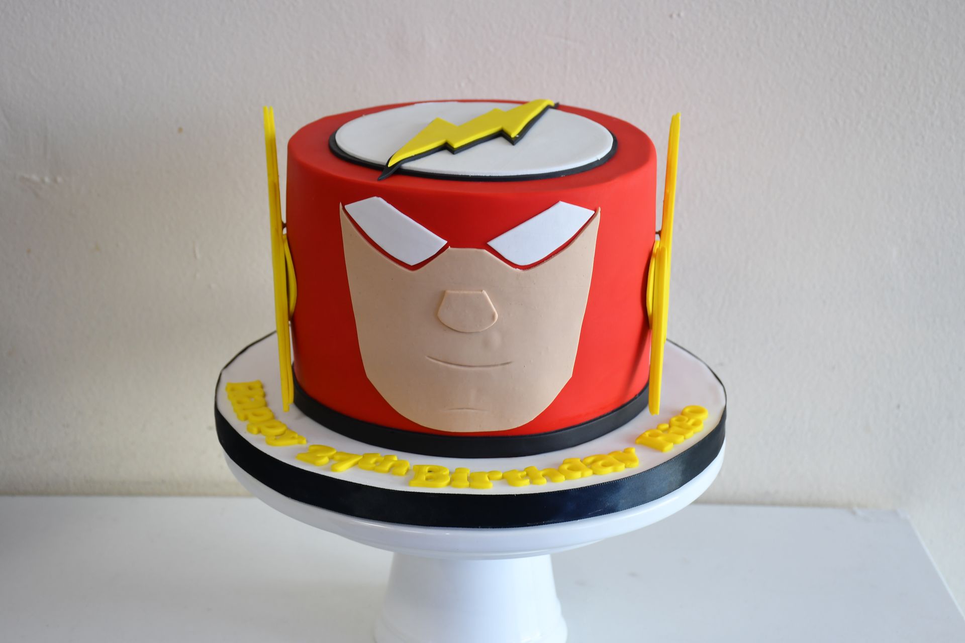 A cake with the face of the flash on it