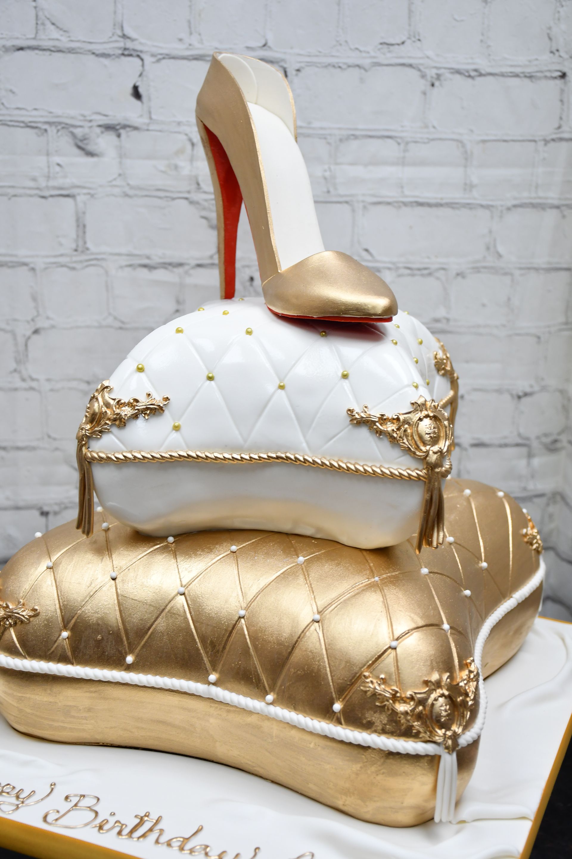 A cake with a high heel on top of a pillow.
