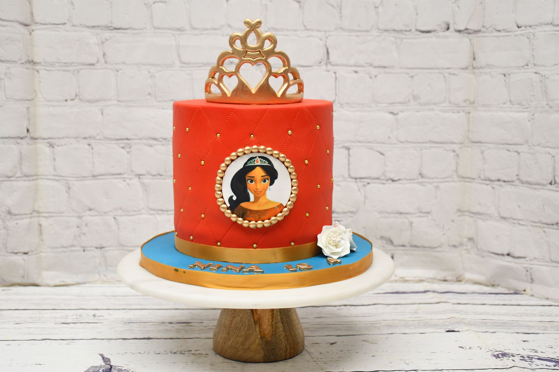A red cake with a picture of a princess on it