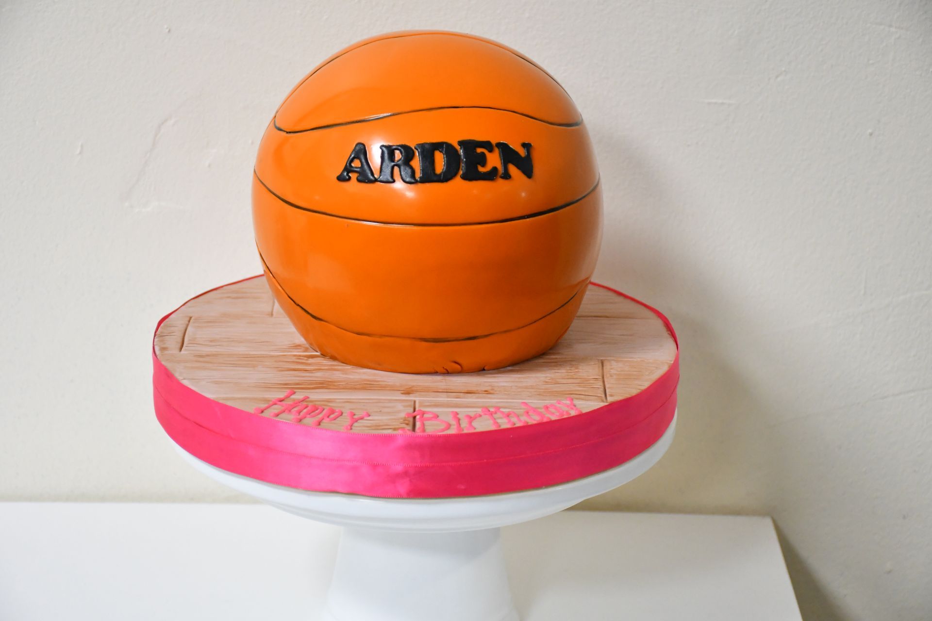 A basketball cake with the name arden on it