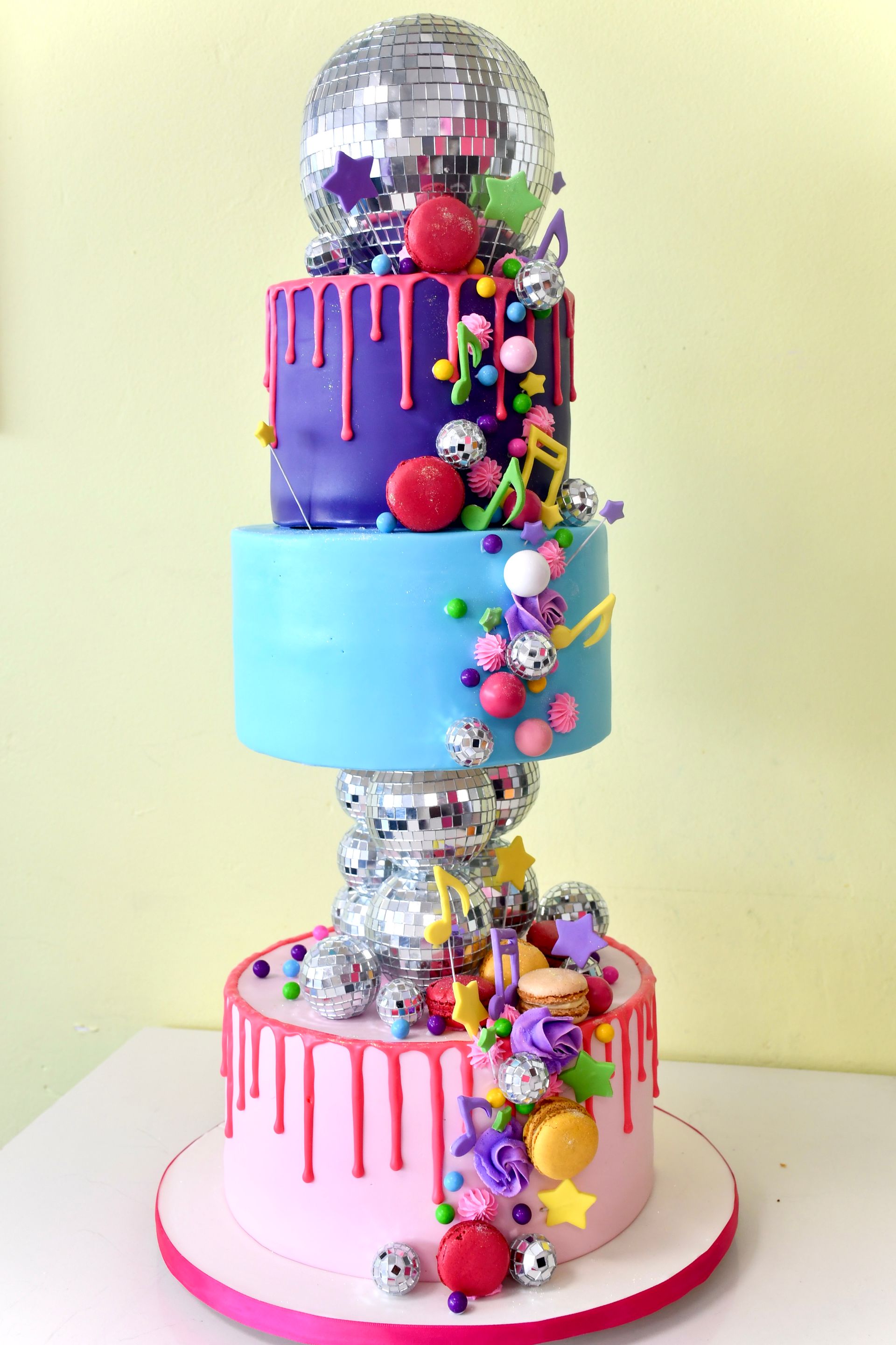 A colorful cake with a disco ball on top of it