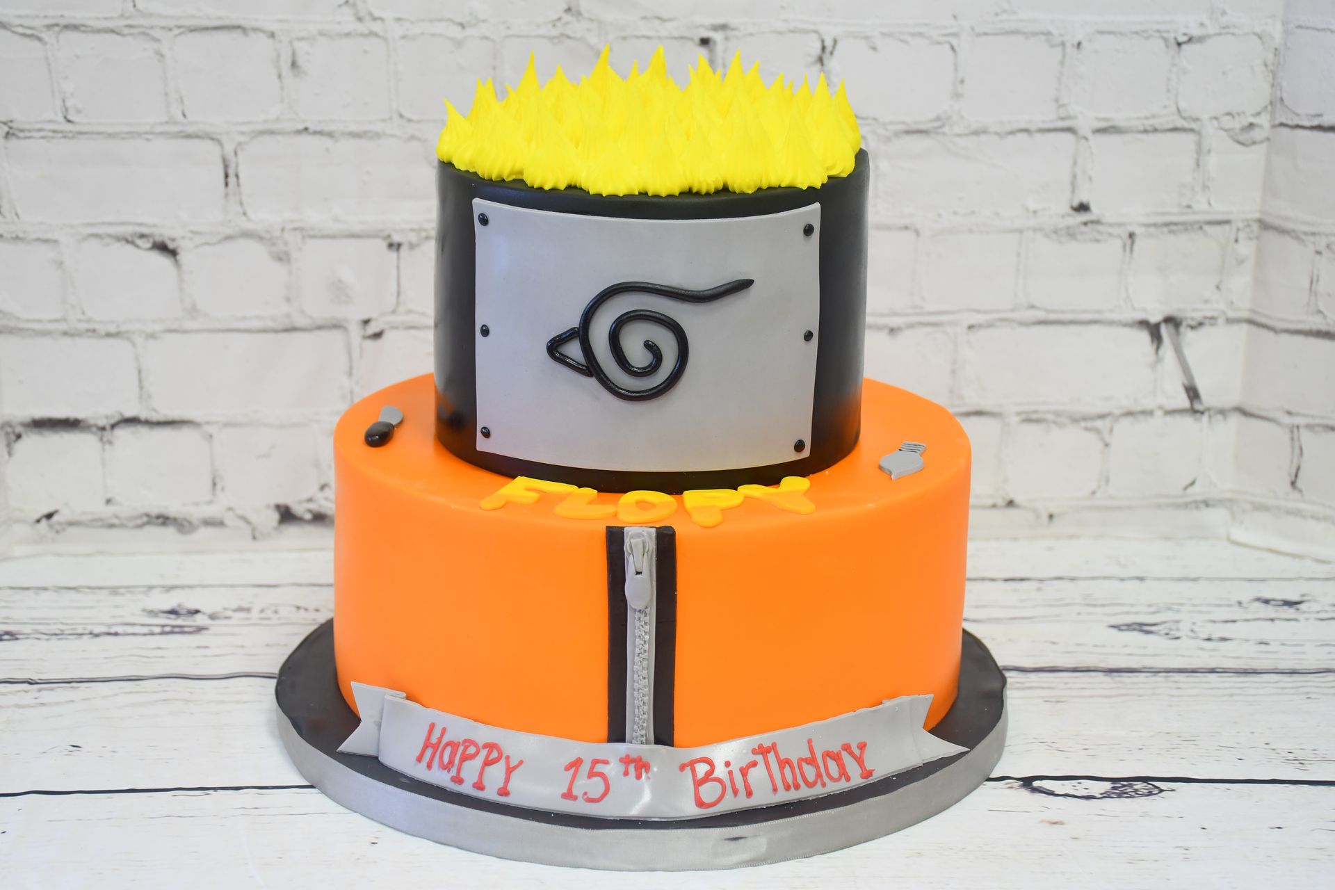 A birthday cake with a naruto logo on it is sitting on a table.