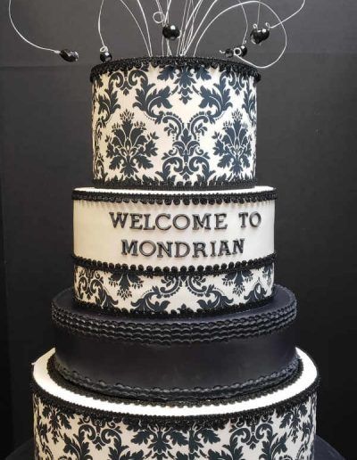 A black and white cake that says welcome to mondrian