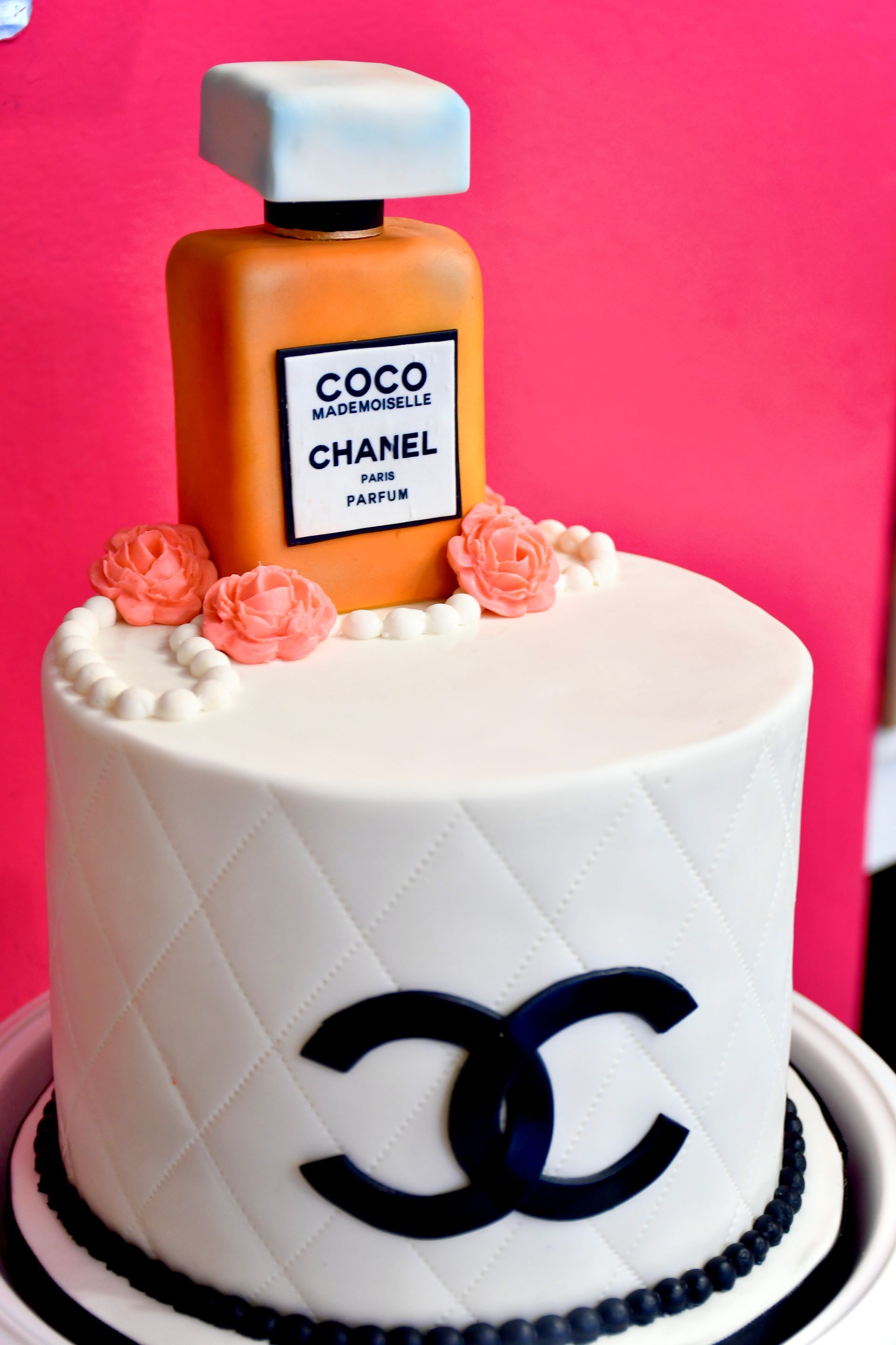A cake with a bottle of coco chanel perfume on top
