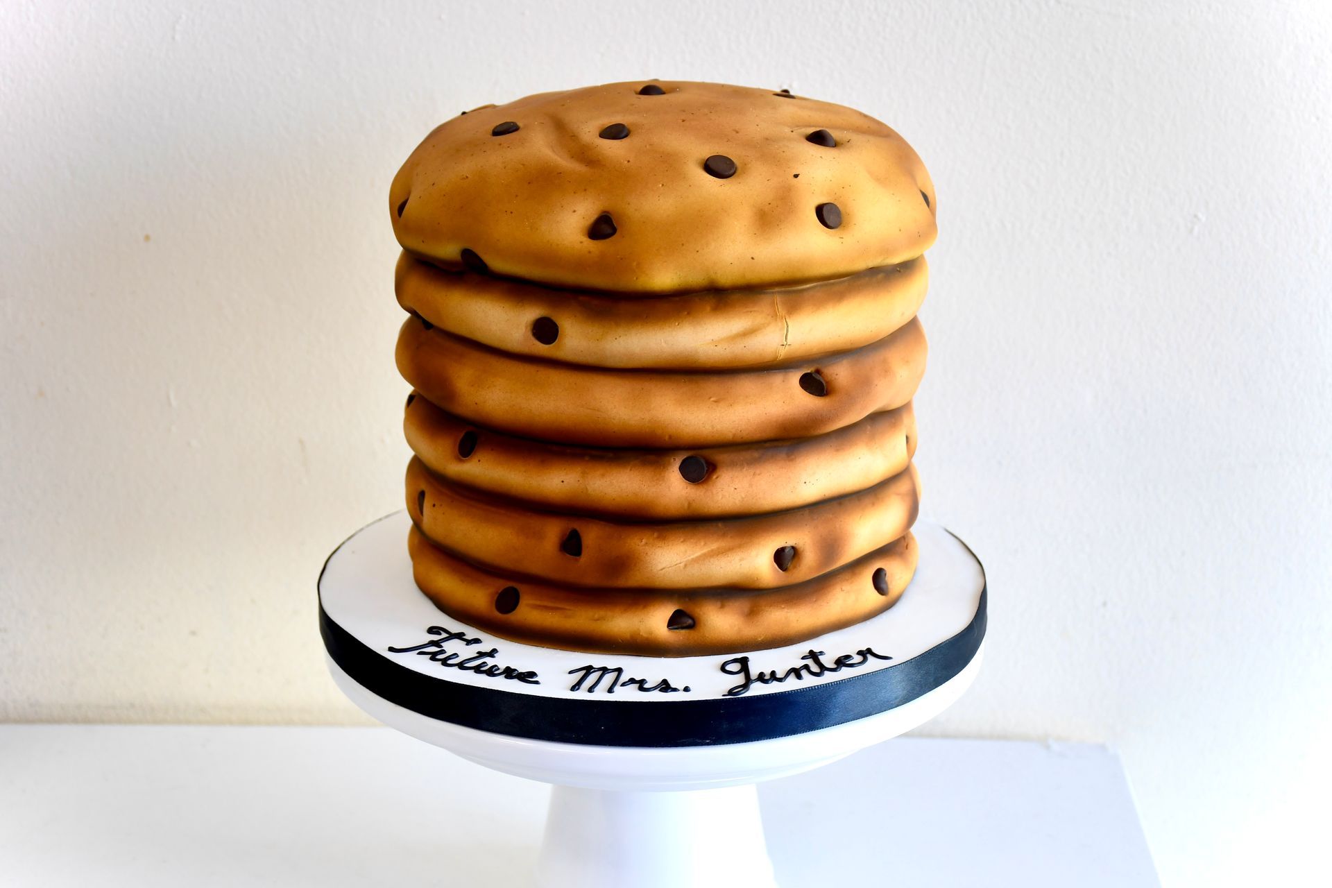 A cake shaped like a stack of chocolate chip cookies