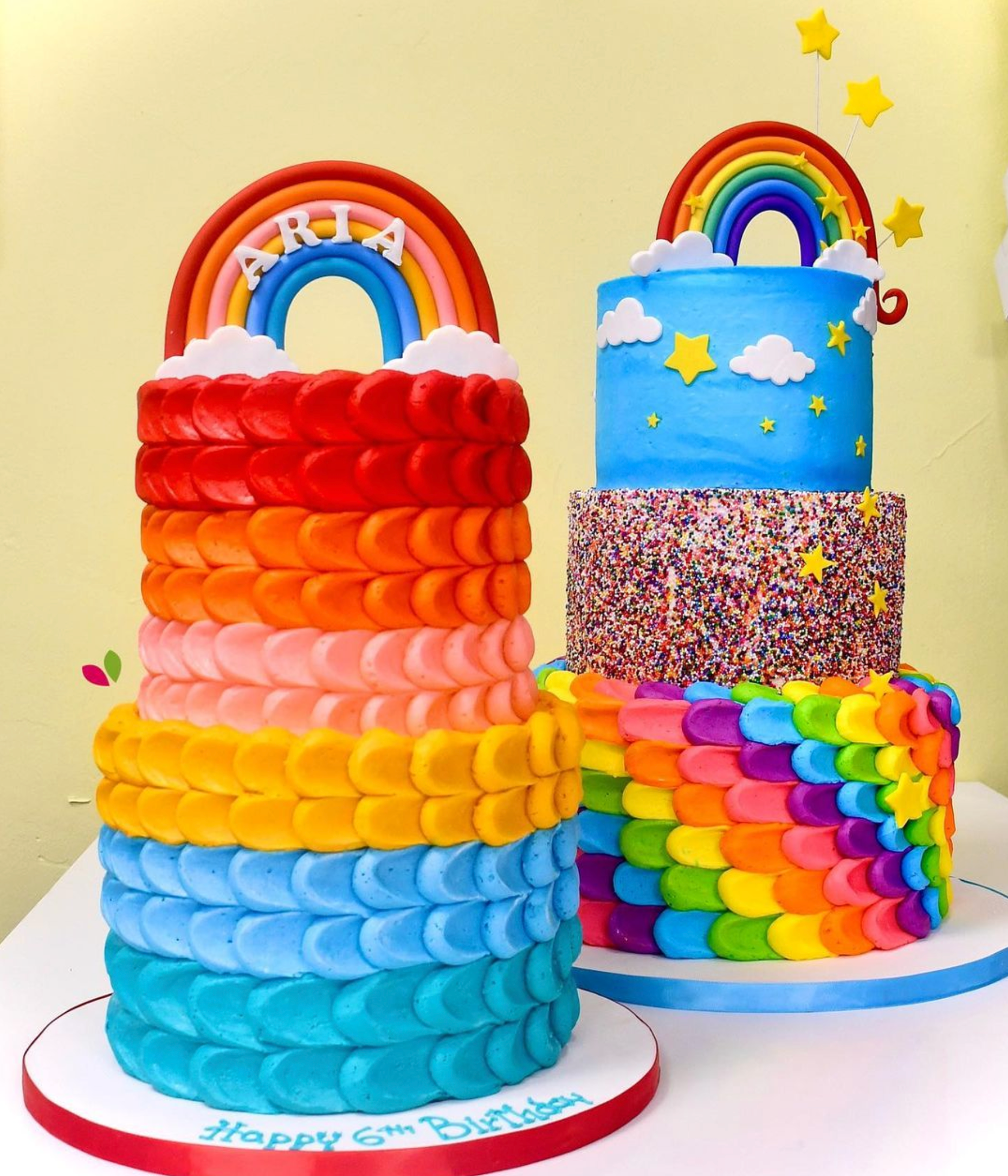 Two colorful birthday cakes with a rainbow on top