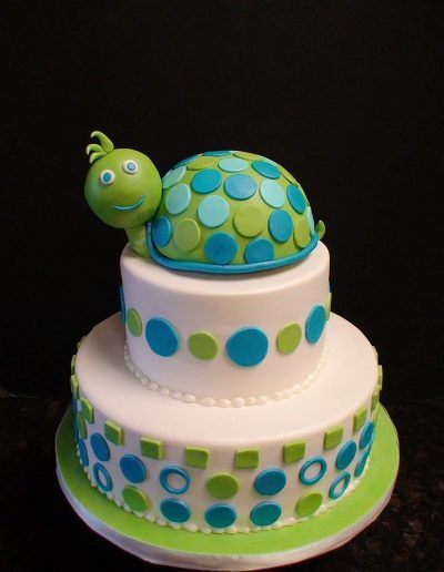 A cake with a green turtle on top of it