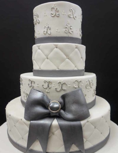 A white cake with a silver bow on it