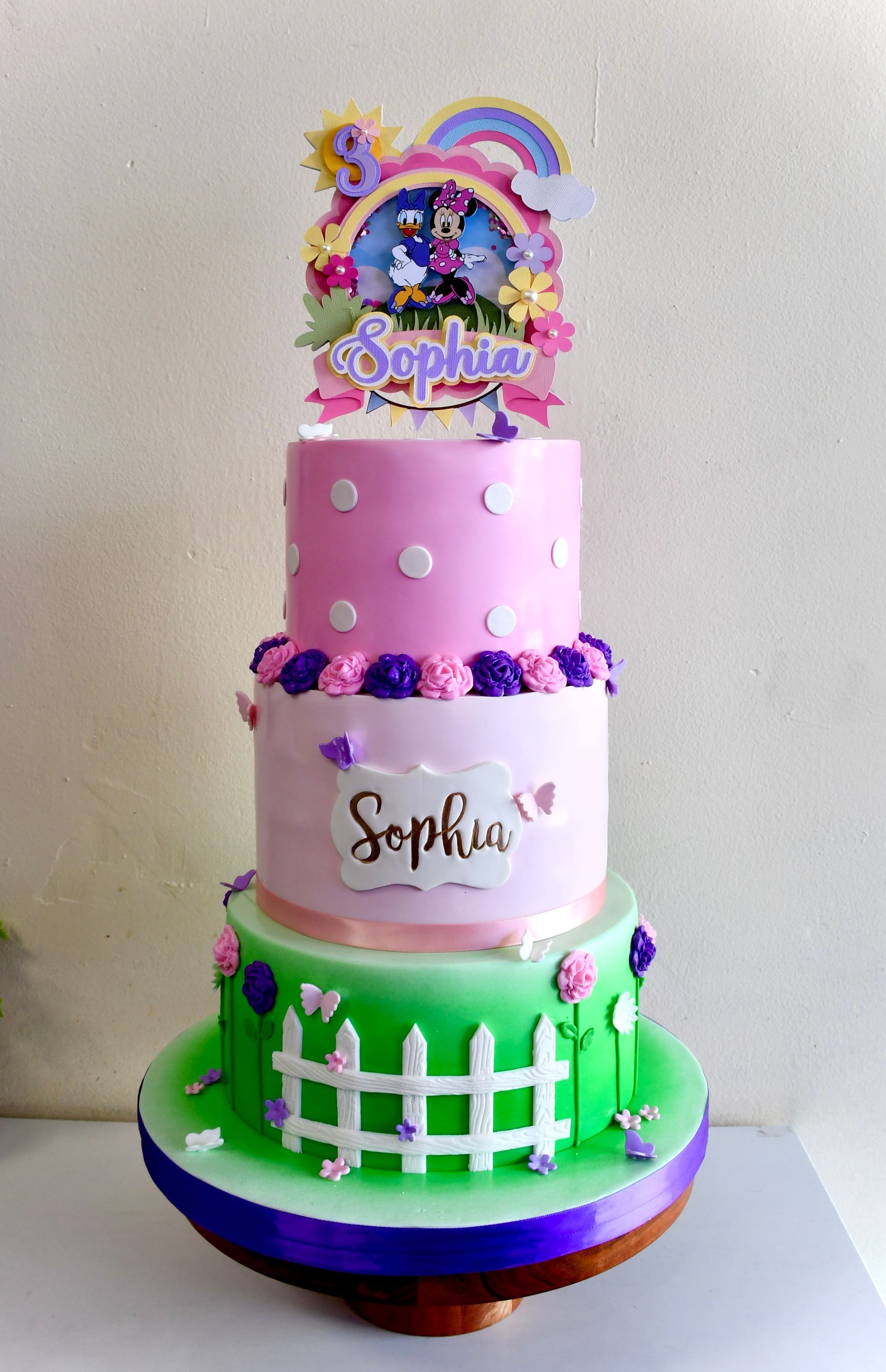 A pink and green cake with the name sophia on it