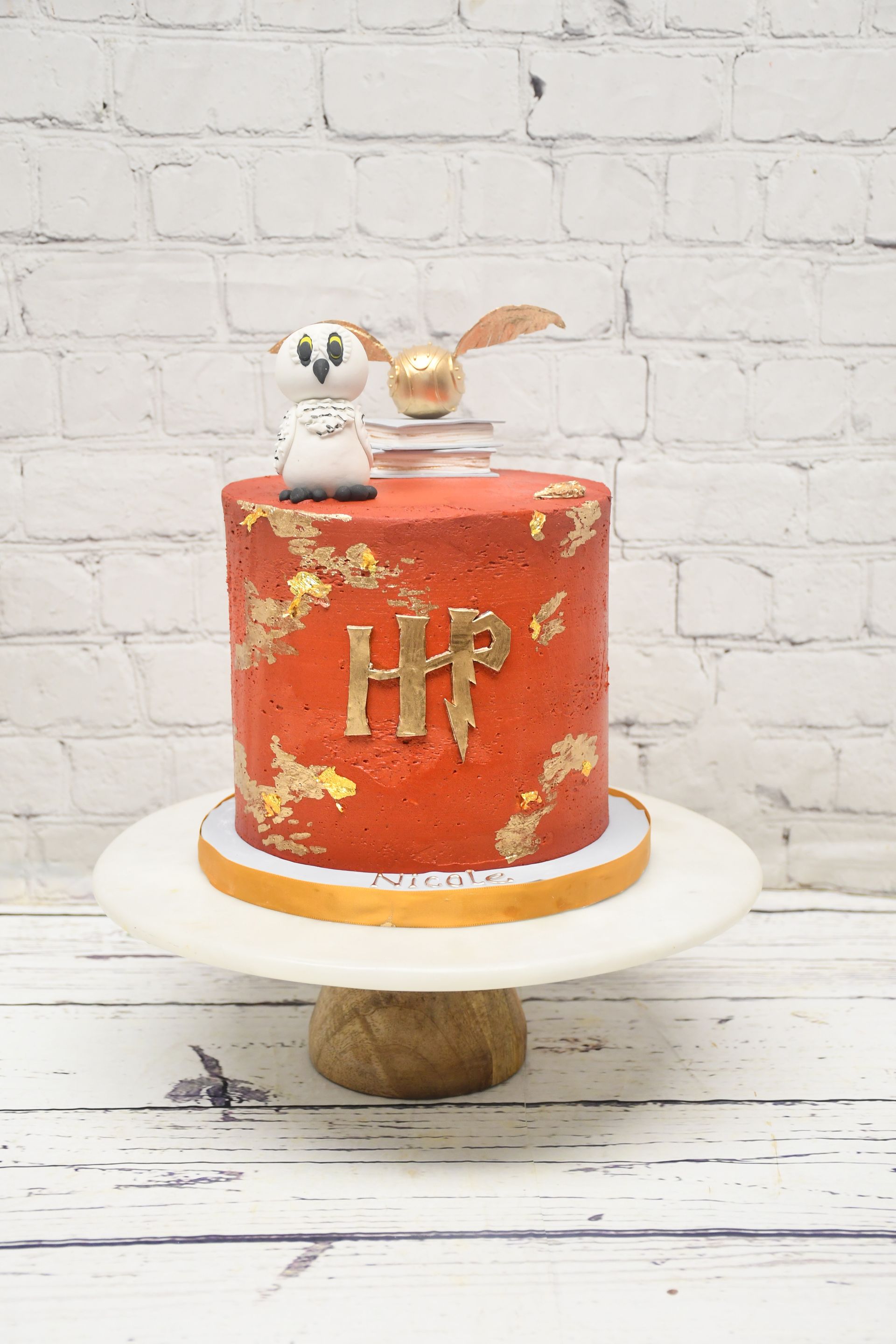 A harry potter cake is sitting on top of a white cake stand.