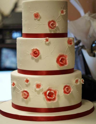 A white cake with red roses on it