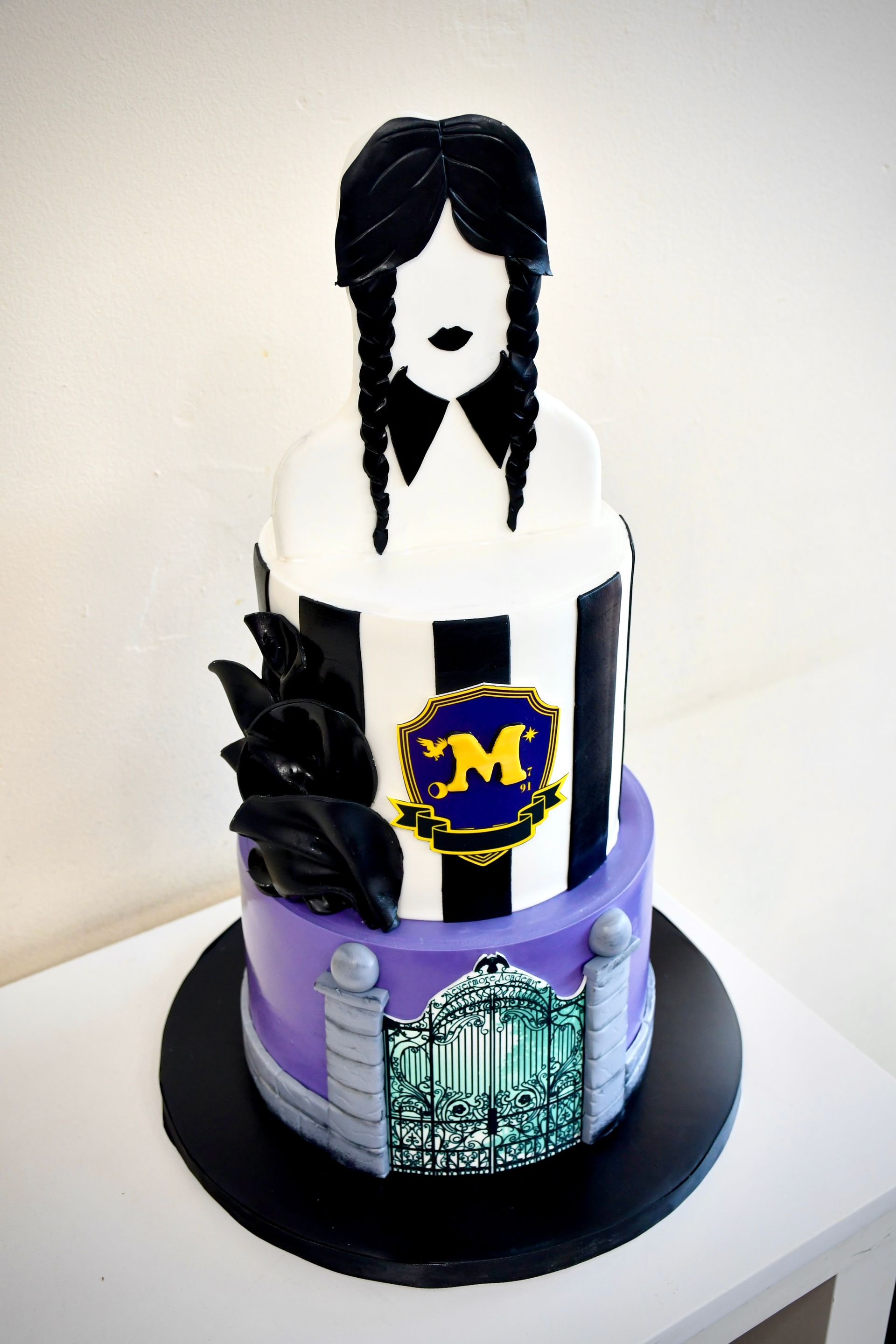 A black and white cake with the letter m on it