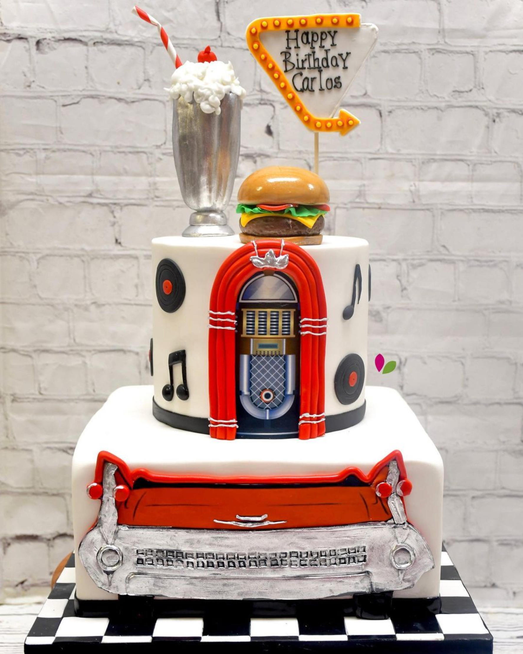 A cake that looks like a diner with a hamburger on top