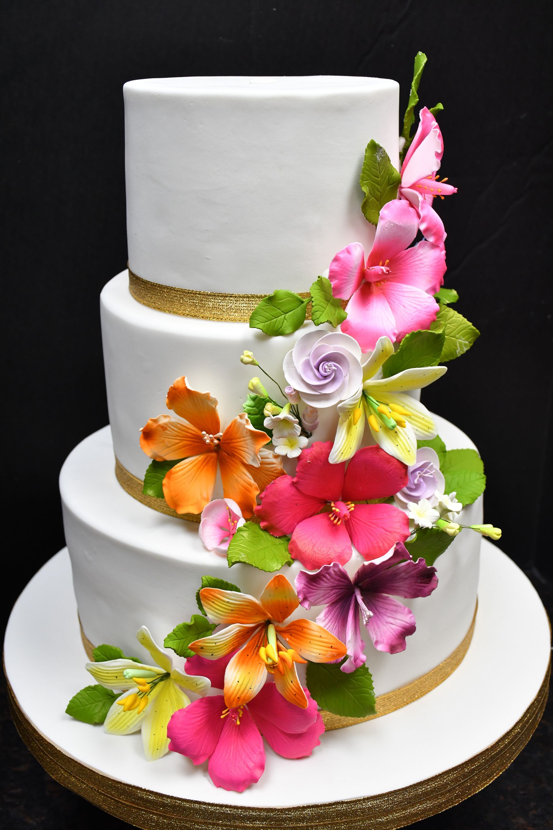 A white wedding cake with colorful flowers on it