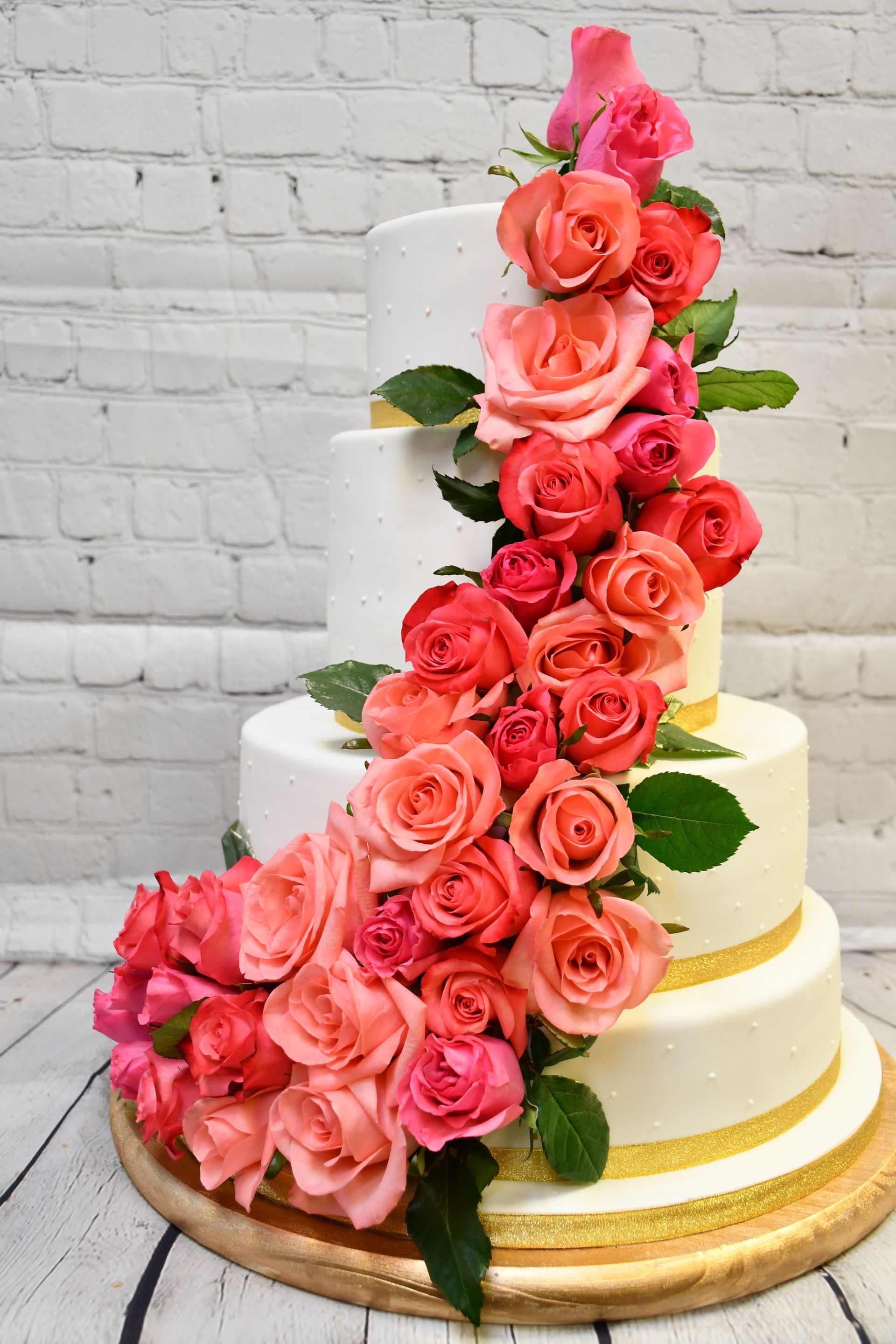 A wedding cake with pink and orange roses on it