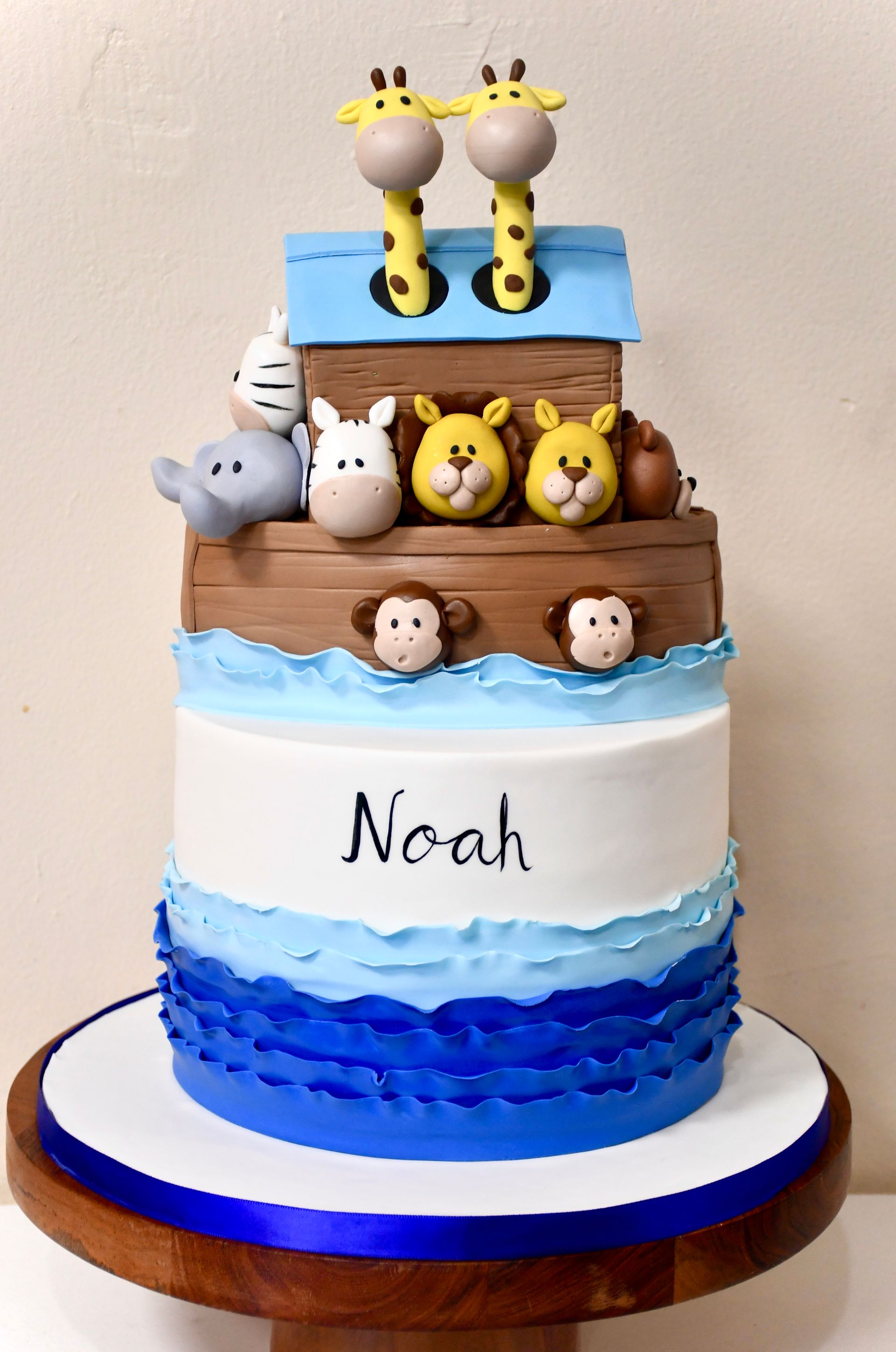 A blue and white cake with the name noah on it