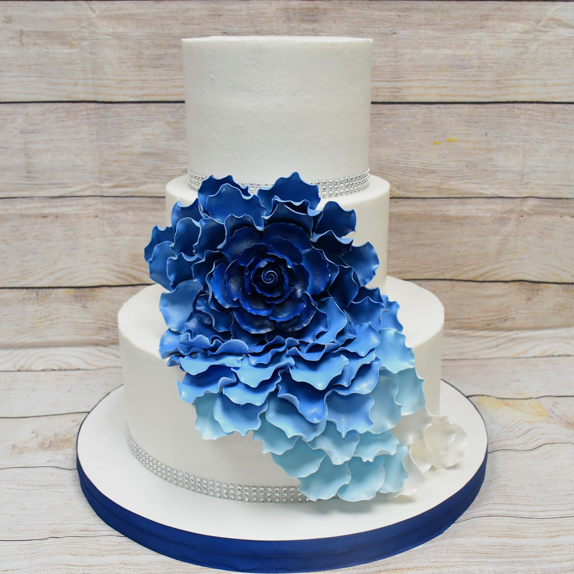 A white wedding cake with blue flowers on it