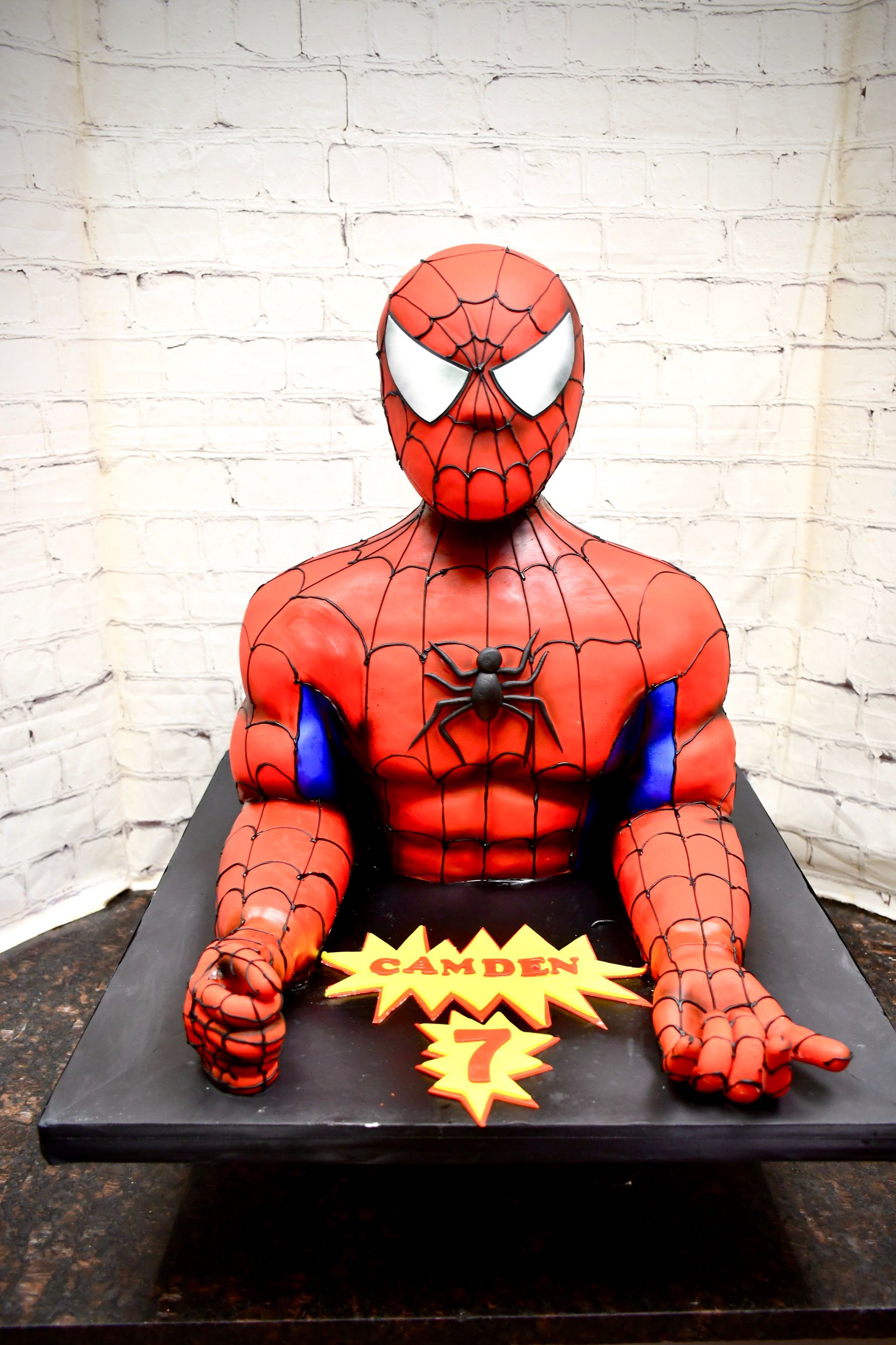 A cake that looks like a spiderman is on a table