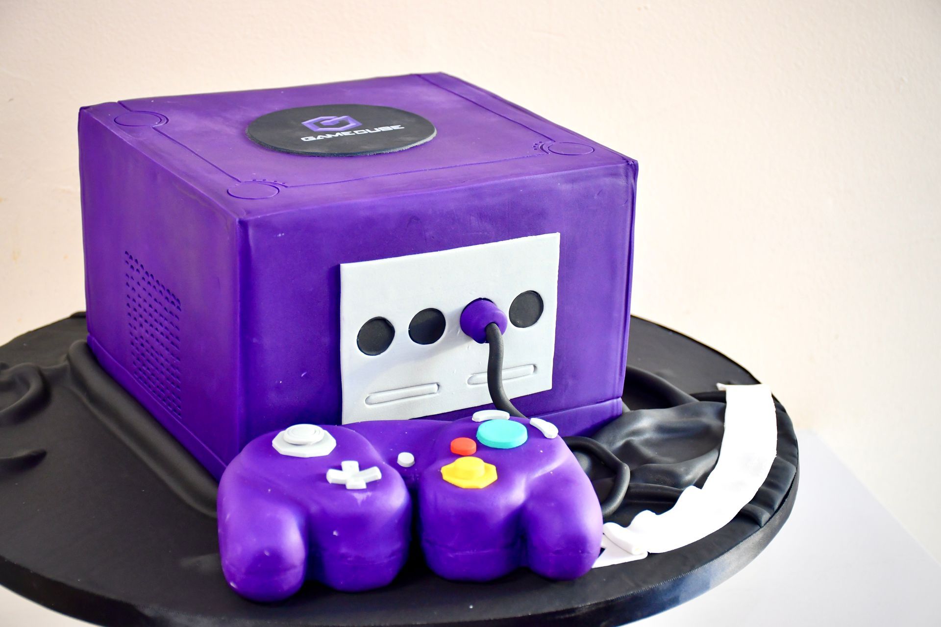 A purple cake with a purple game controller on top of it