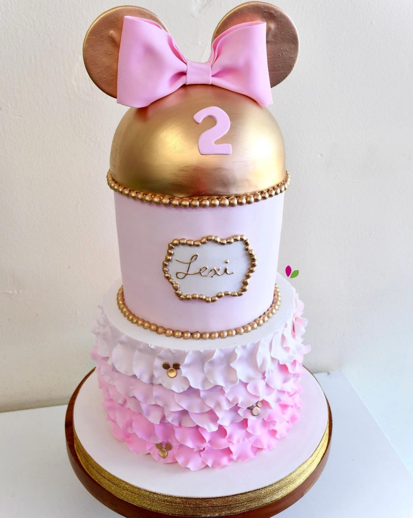 A pink and gold cake with the number 2 on it