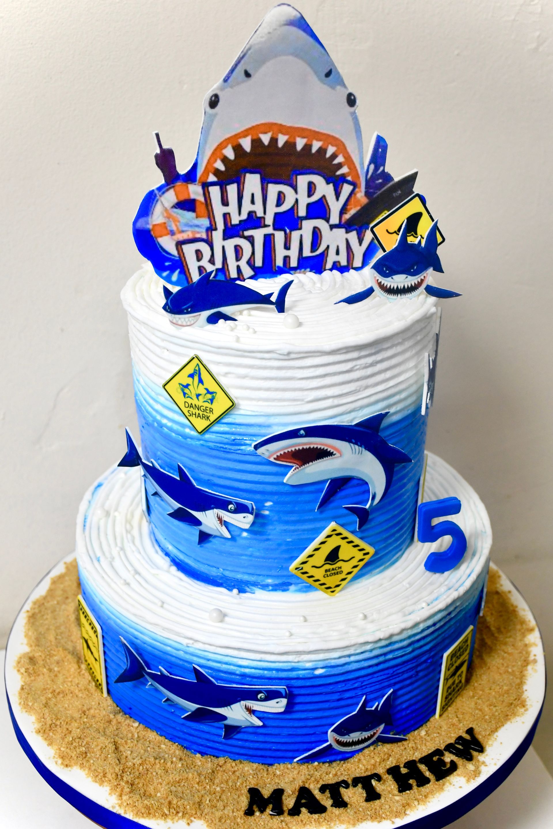 A birthday cake for matthew with sharks on it