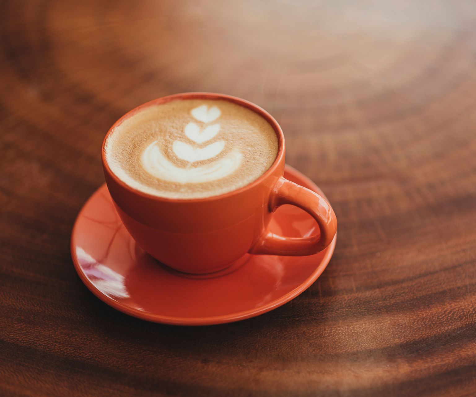 A cup of cappuccino on a saucer on a wooden table