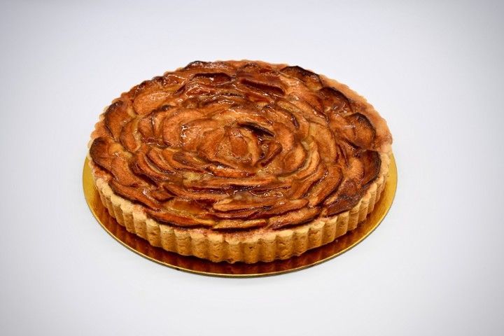 An apple pie is sitting on a plate on a white background.