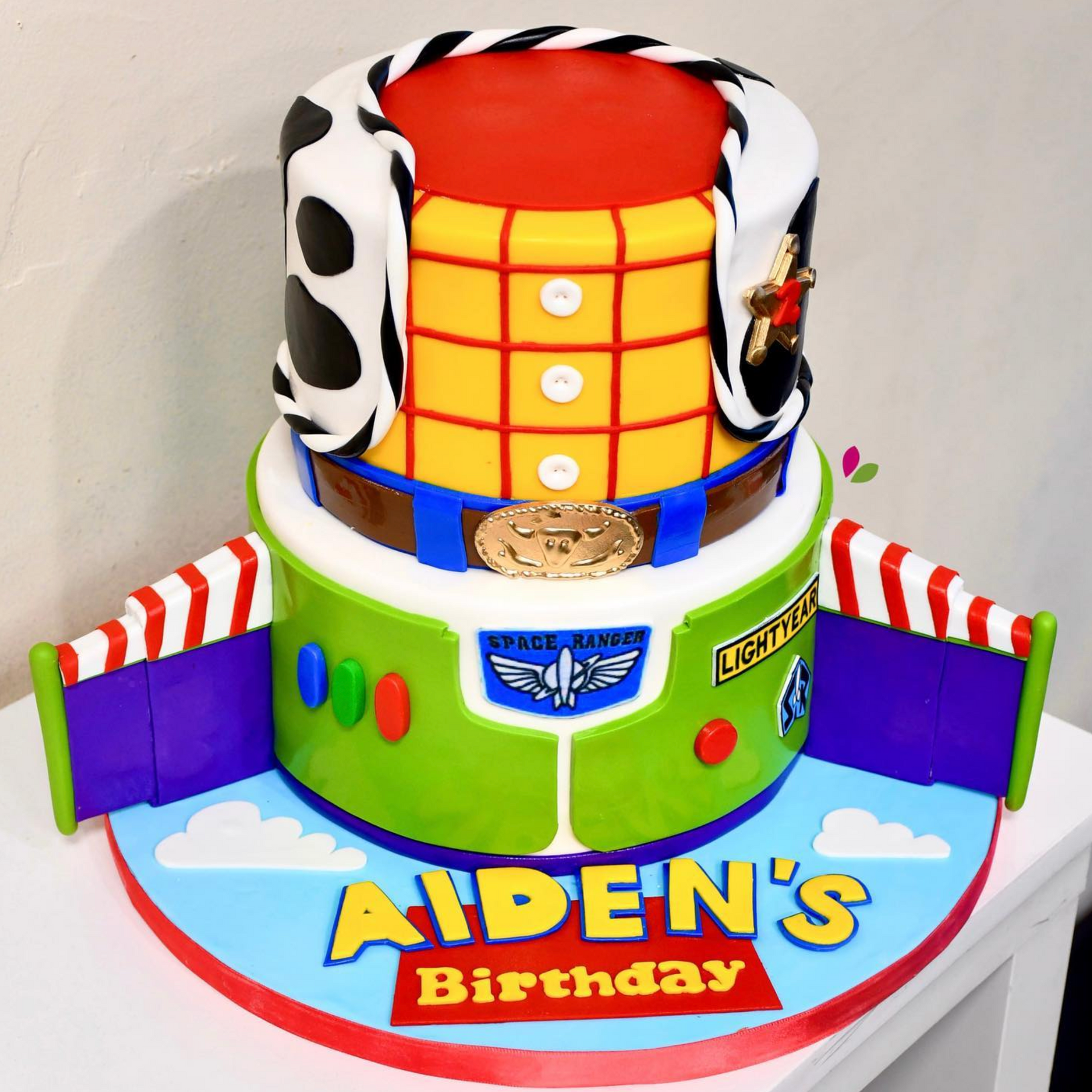 A birthday cake for aiden 's with woody and buzz lightyear on it