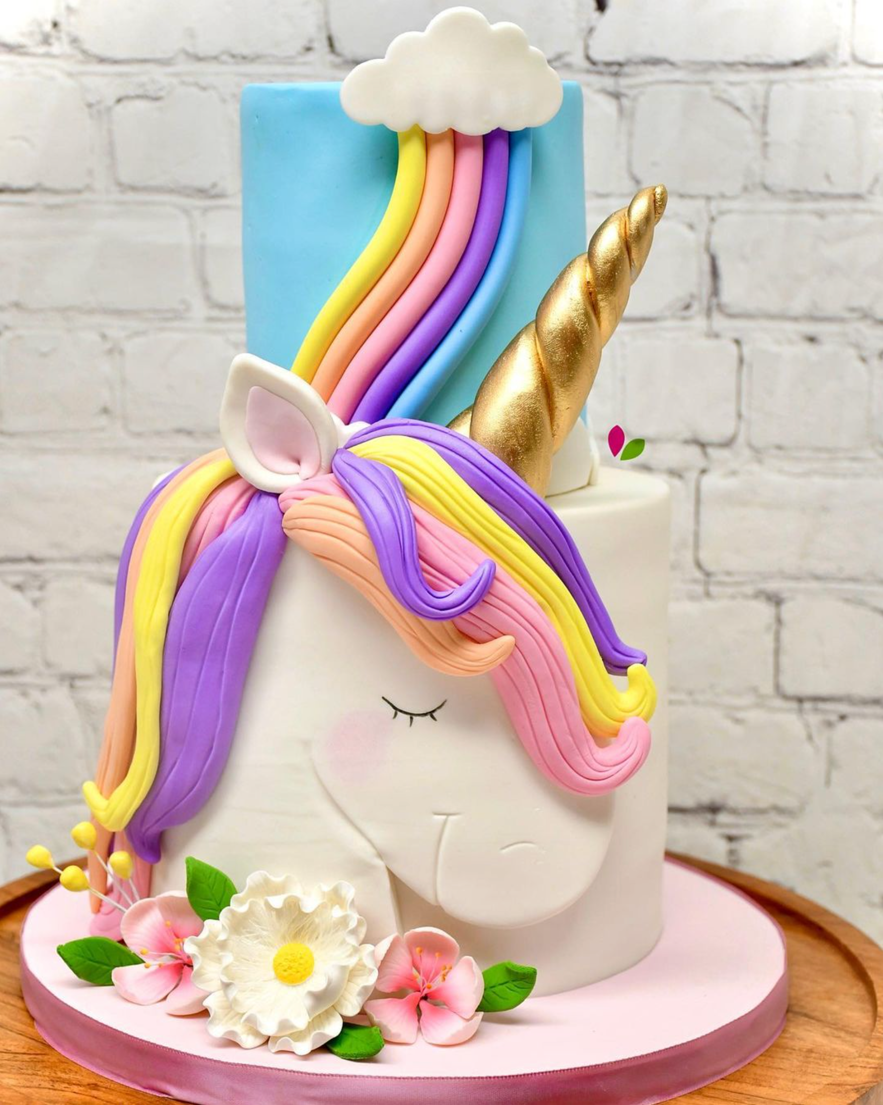 A unicorn cake with a rainbow and flowers on it