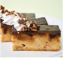 A piece of cake with whipped cream and nuts on top