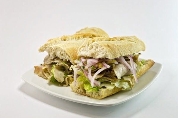Two sandwiches on a white plate on a white background.
