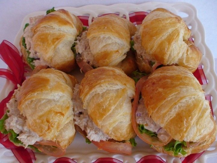 A bunch of sandwiches on croissants on a plate
