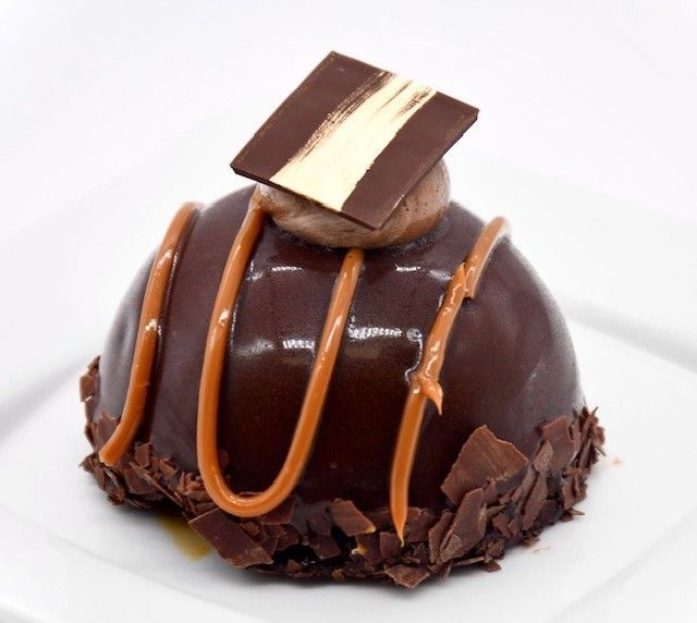 A chocolate dessert with a square of chocolate on top