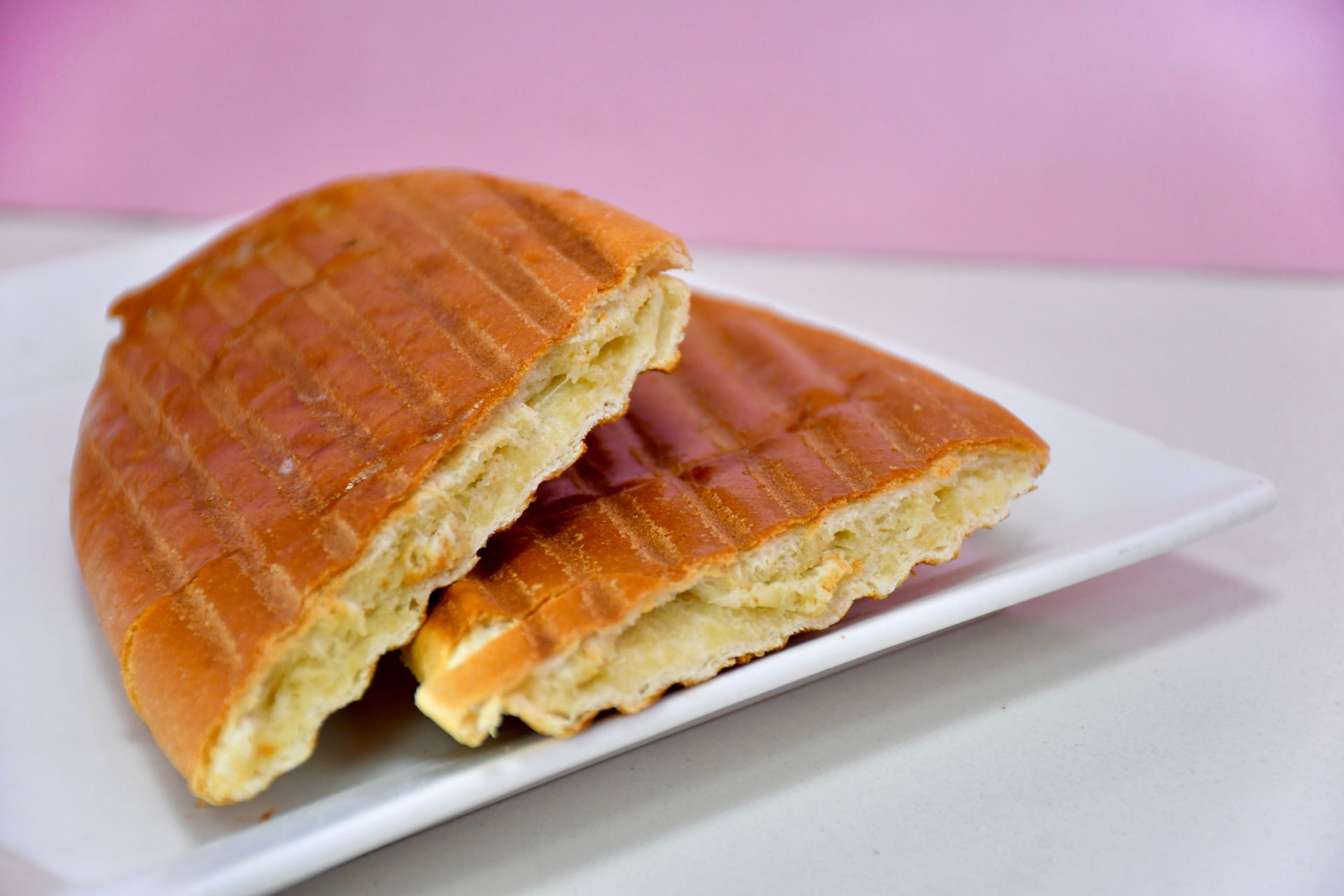 Two pieces of bread are sitting on a white plate.