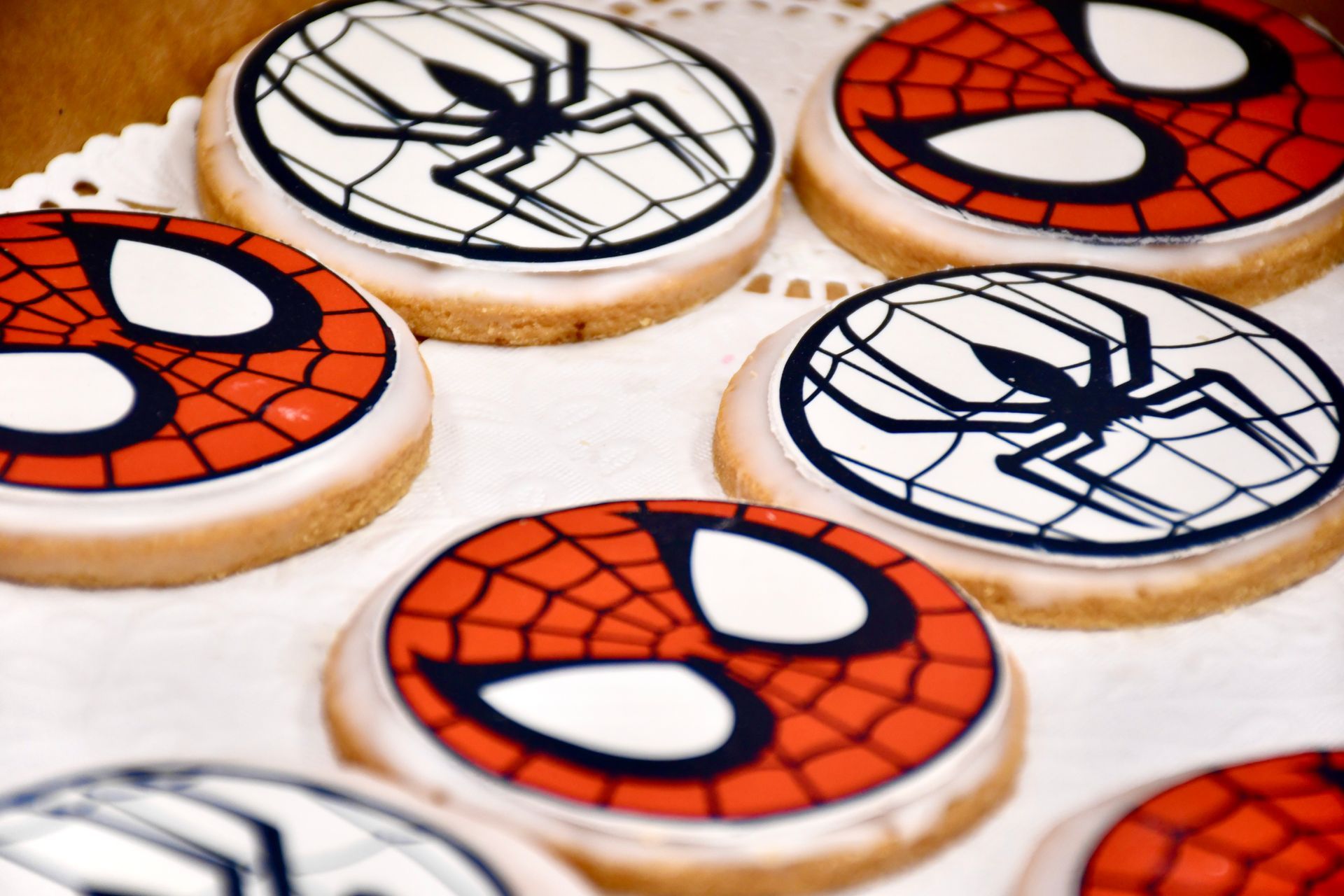 A bunch of cookies with spider man faces on them
