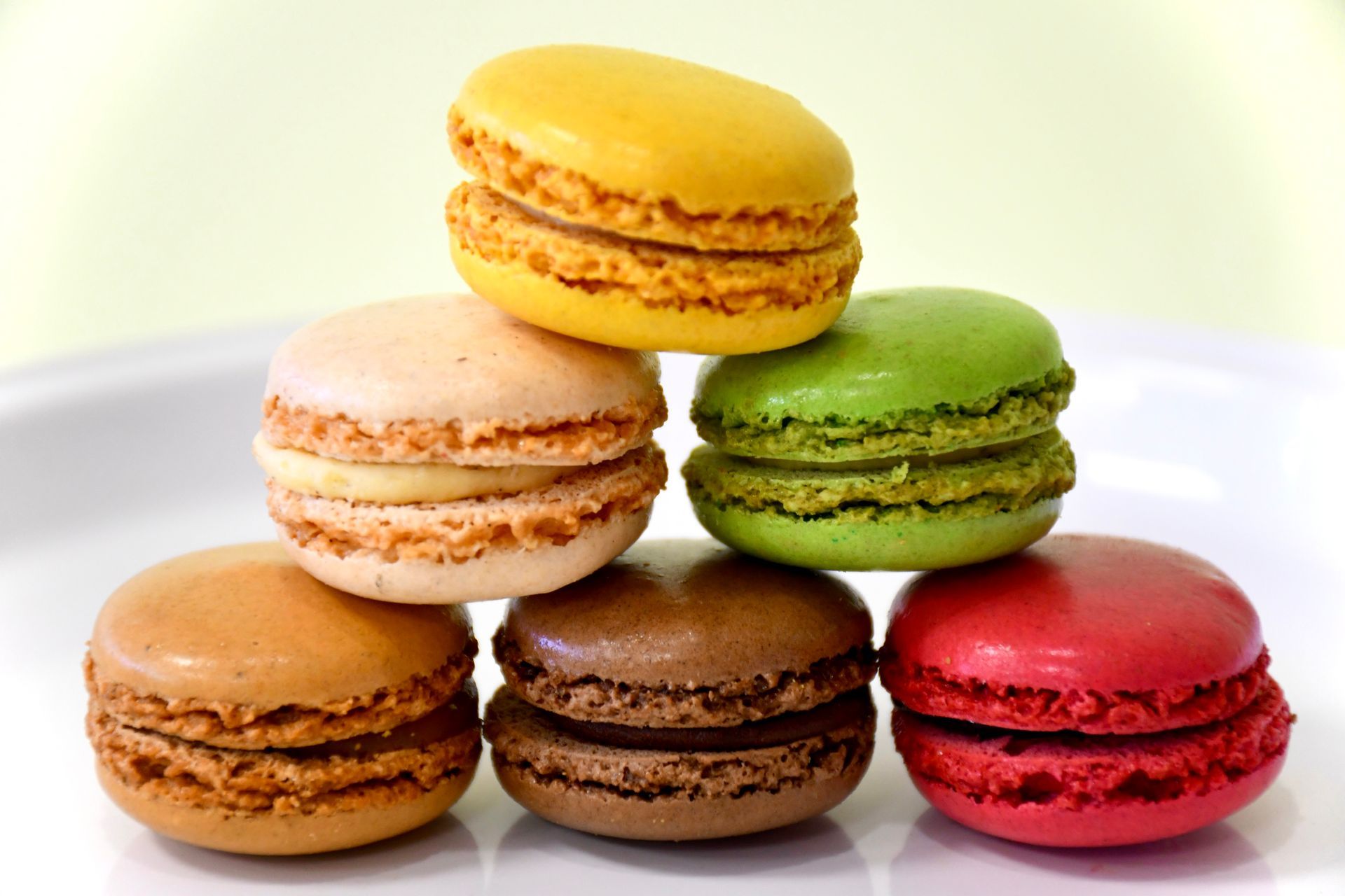 The macarons are stacked on top of each other on a white plate.