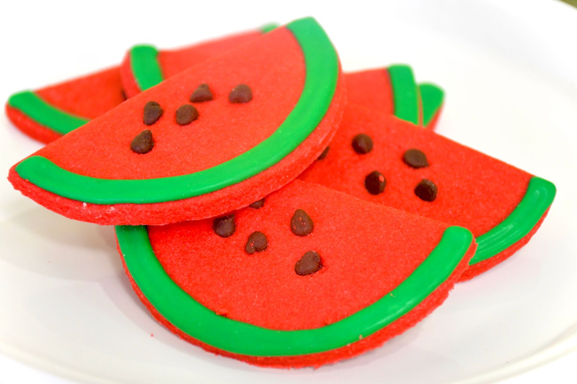 A white plate topped with watermelon shaped cookies