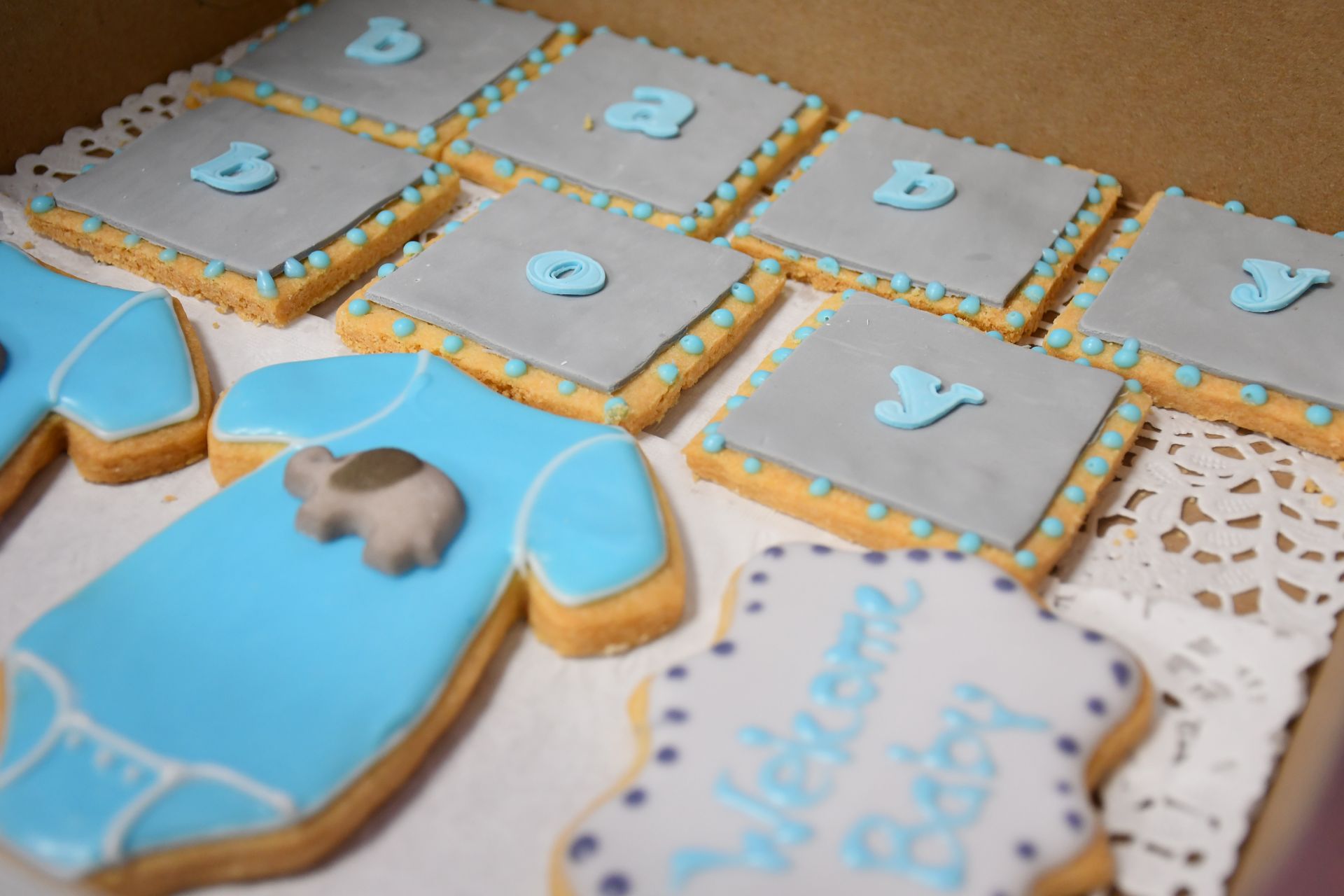 A box filled with baby shower cookies for a boy