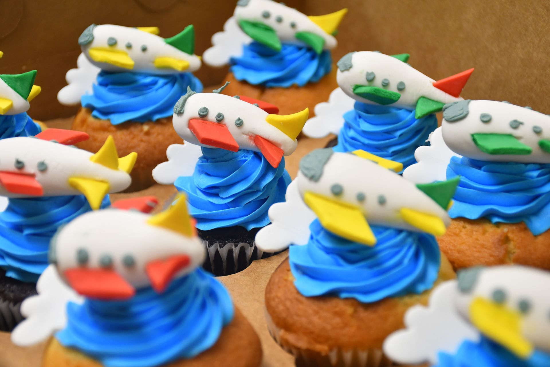 A box of cupcakes with airplanes on top of them