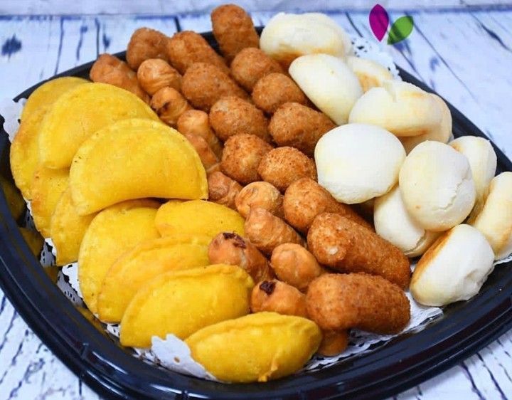 A black tray filled with different types of food on a table.