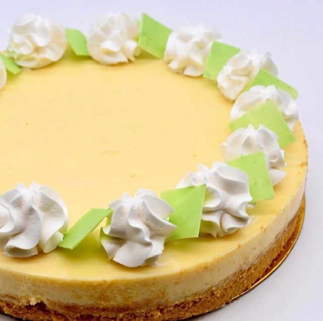 A cheesecake with whipped cream and green leaves on top