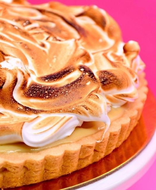 A close up of a pie with a pink background