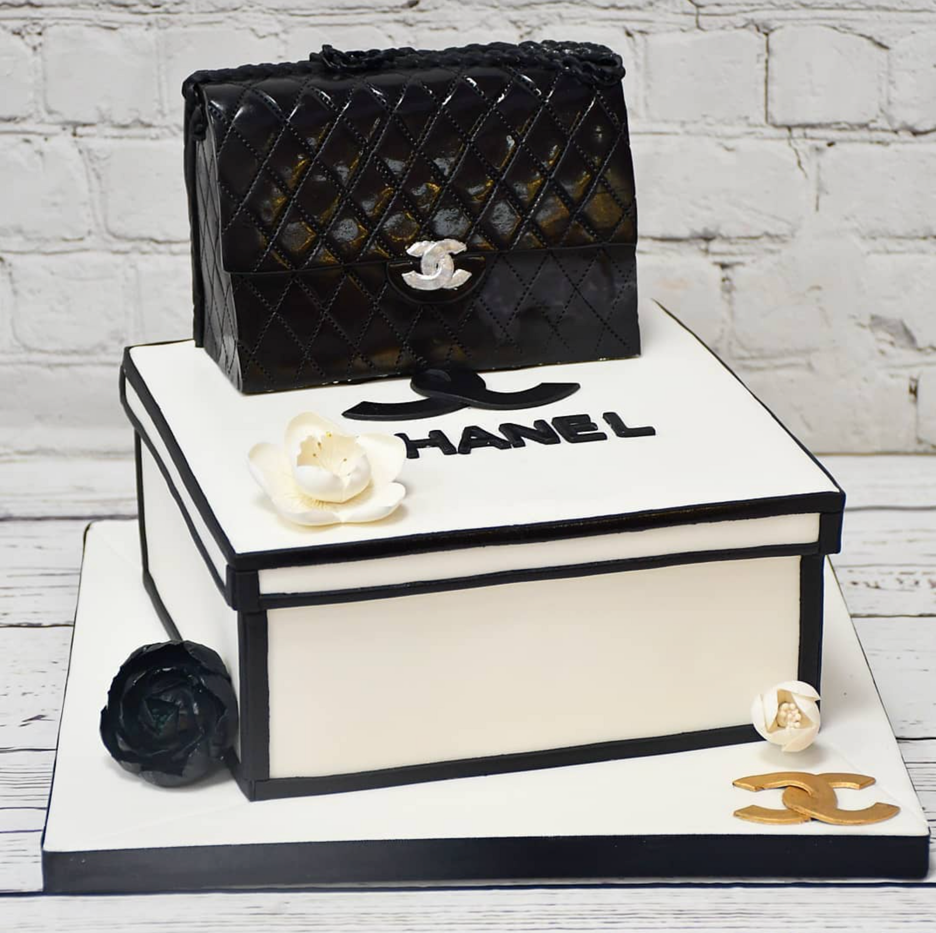 A chanel cake with a chanel black purse on top