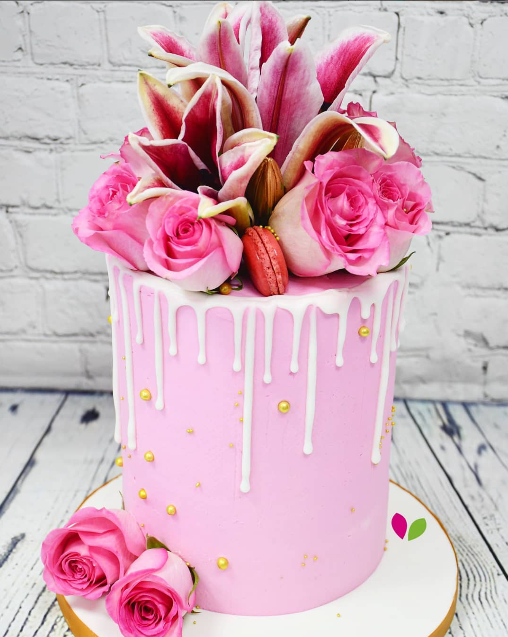 A pink cake with pink flowers on top of it